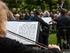 Szenenfoto "Begehbare Sinfonie": Blick über die Schulter einer Bratschistin während sie Mozart spielt, im Hintergrund weitere Musiker und der Dirigent