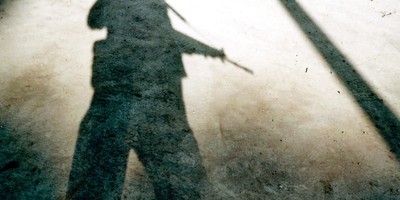 Der Schatten eines gewehrtragenden Soldaten.
