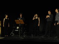 Fünf Personen auf einer Bühne in einem Halbkreis während einer musikalischen Darbietung